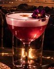Cóctel rojo con espuma y flor morada en BarX9